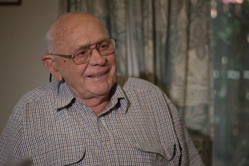 Walter wears glasses and a button-up t-shirt.