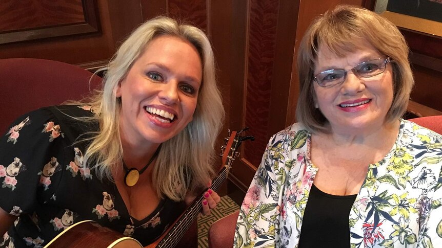Beccy Cole, holding a guitar, sitting next to her mother, Carole Sturtzel.