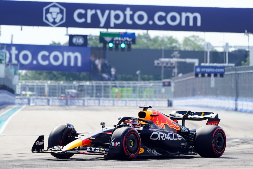 a formula 1 car turns on the racetrack under a Crypto-com billboard