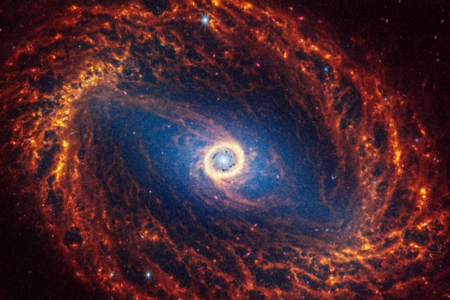 Spiral galaxy NGC 1512 bright orange arms compared to Hubble's light grey imagery 