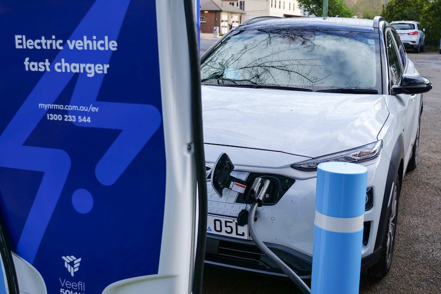 Electric car with charger in foreground.