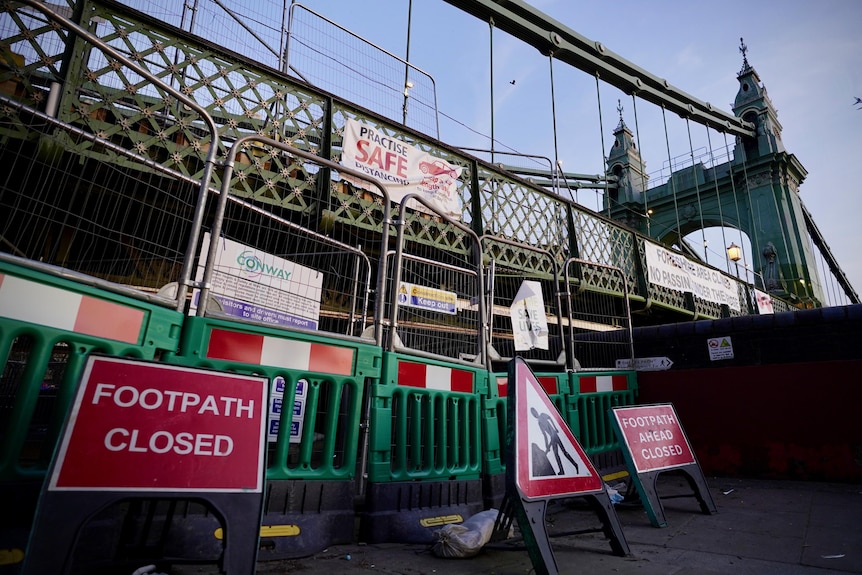 Repair signs stand in front of Hammersmith Bridge.