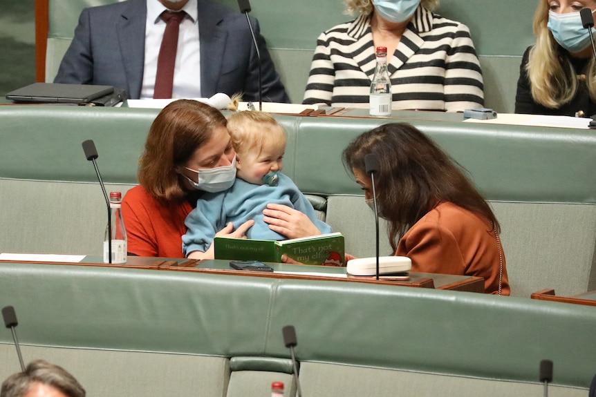 Lisa Chesters holds her son, who is giggling with Anne Aly 