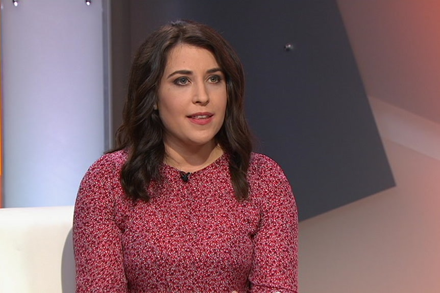 Annika Smethurst sits on a white couch for the television program Insiders.