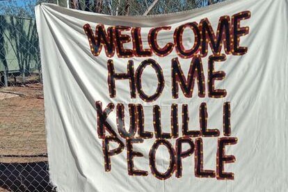 A sign hung on fence posts that reads "Welcome Home Kullilli People".