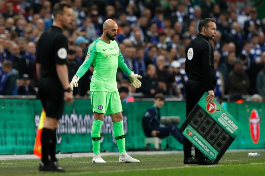 Willy Caballero stands with his hands outstretched on the sideline
