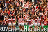 Japan players celebrate in front of fans after beating Samoa
