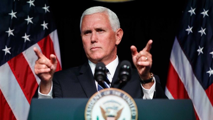 Mike Pence stands at a lectern pointing with both fingers.