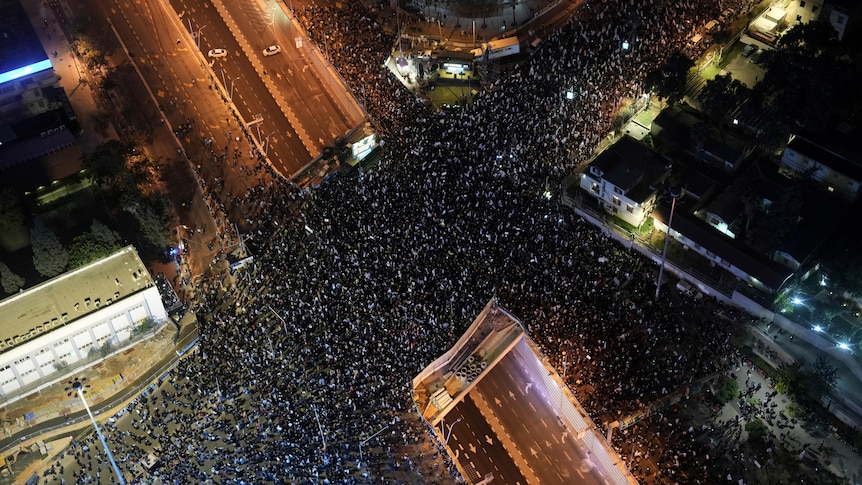 Thousands of protests fill the streets in an aerial view.