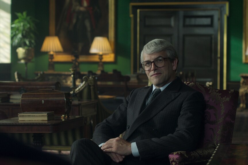 A production still of John Major sitting in his office.