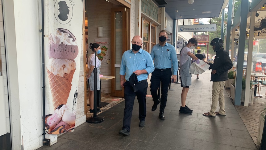 two men walking with coverings over their mouths