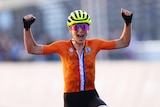 Annemiek van Vleuten raises her hands and laughs as she crosses the line.