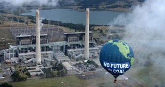 A hot air balloon, saying "no future in coal", floats close to the Liddell power station.
