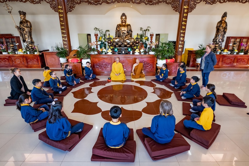 A photo of the kids sitting in a circle.