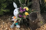 A stuffed rabbit and a bouquet of flowers can be seen lying outside the Kiddy Palace childcare centre.