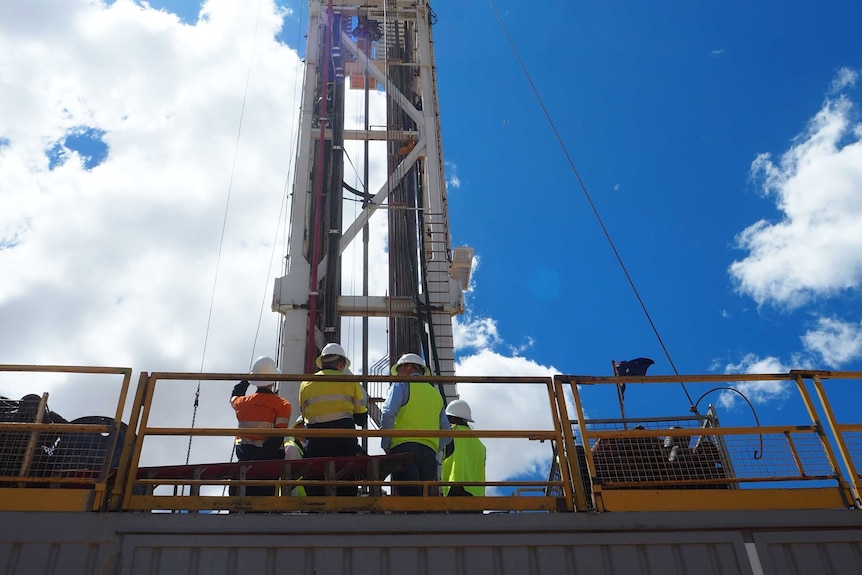 Looking up at a drill rig from the ground with it extended into the sky