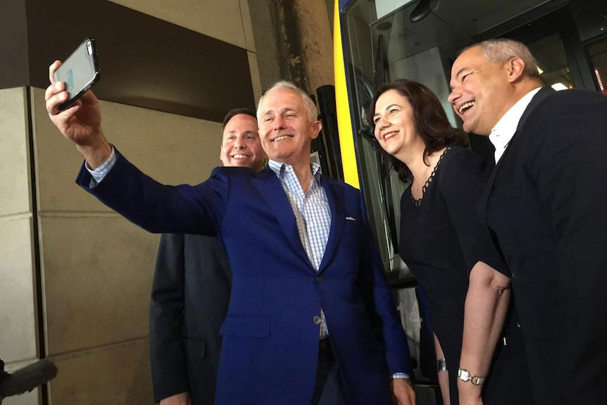Prime Minister Malcolm Turnbull takes a selfie, with Queensland Premier Annastacia Palaszczuk and Gold Coast Mayor Tom Tate (R)