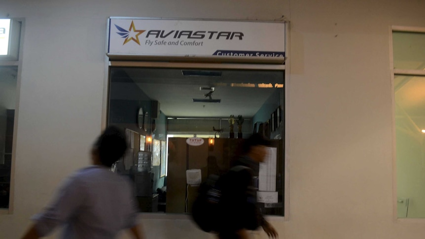 People walk past the Aviastar airline office in South Sulawesi