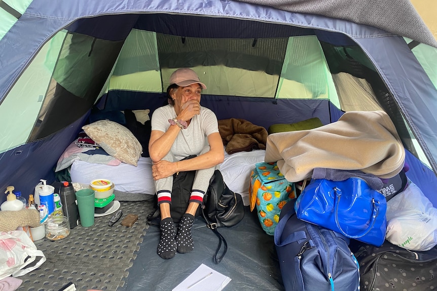 An image of Nicole in her tent surrounded by belongings 