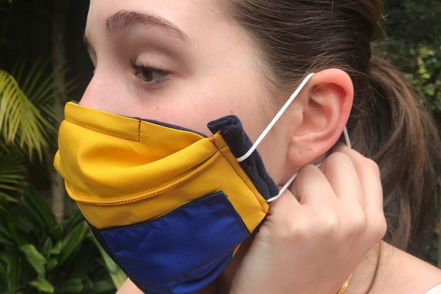 A young woman wears a homemade mask.