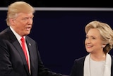 Donald Trump and Hillary Clinton smile as they shake hands during the second US presidential debate.