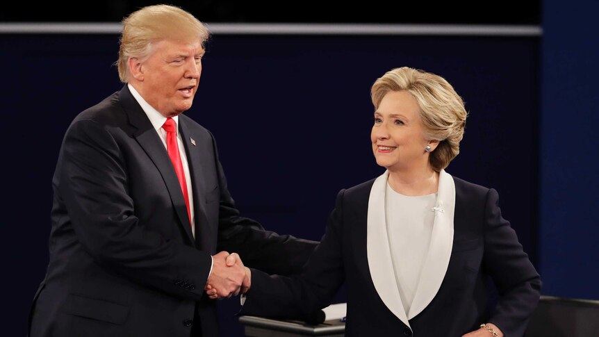 Donald Trump and Hillary Clinton smile as they shake hands during the second US presidential debate.