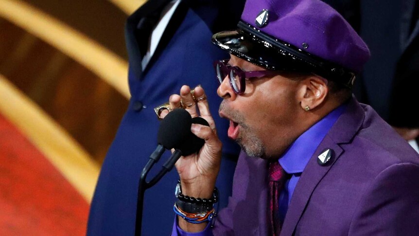 Spike Lee yells into the microphone onstage