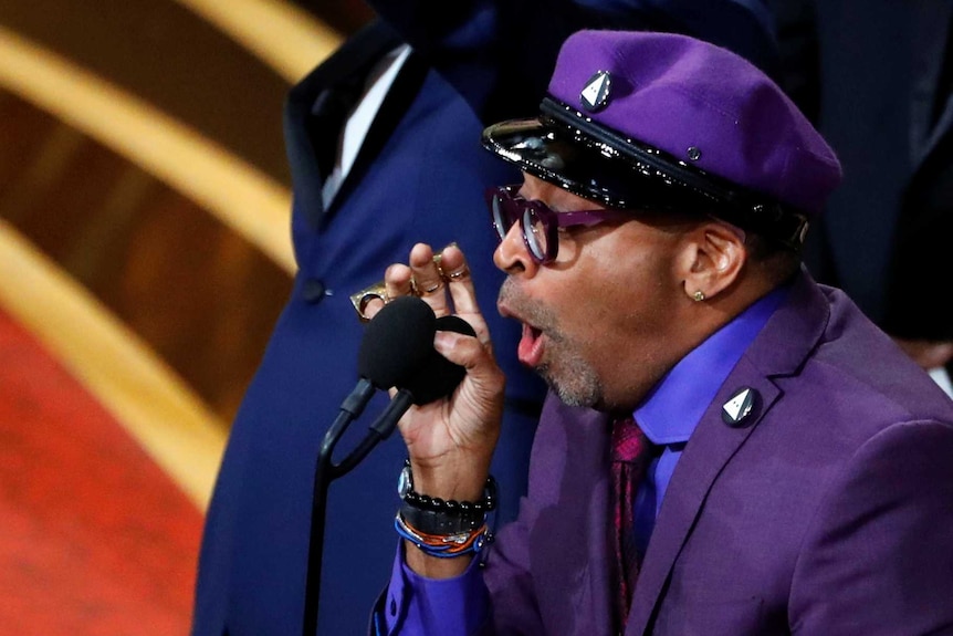 Spike Lee yells into the microphone onstage