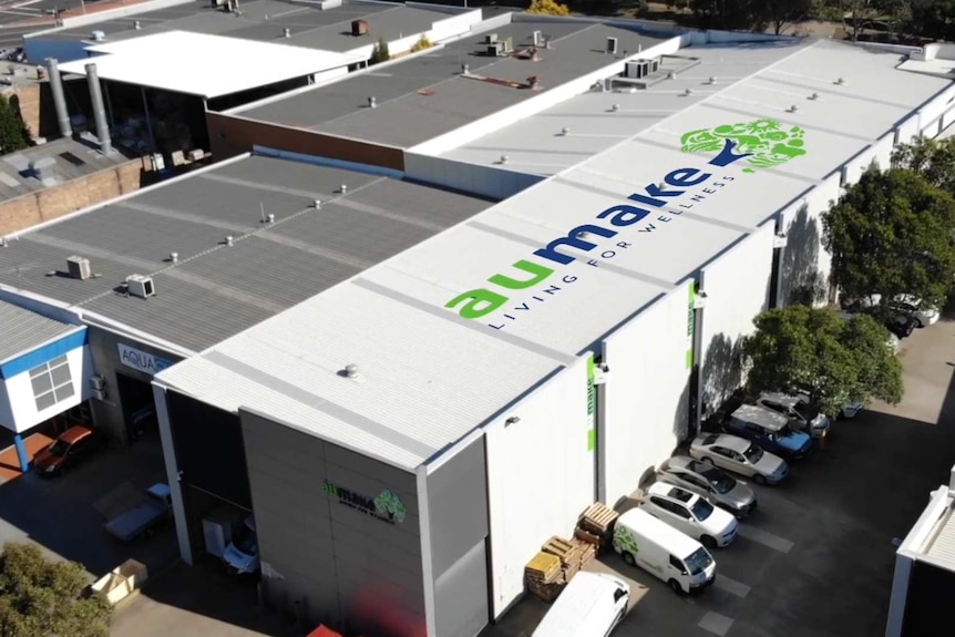An aerial view of a warehouse with AuMake's logo on the roof.