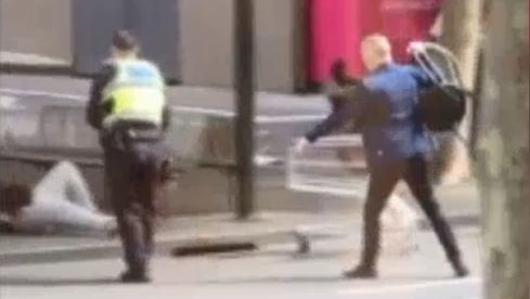 A man holds a chair during the Bourke Street attack