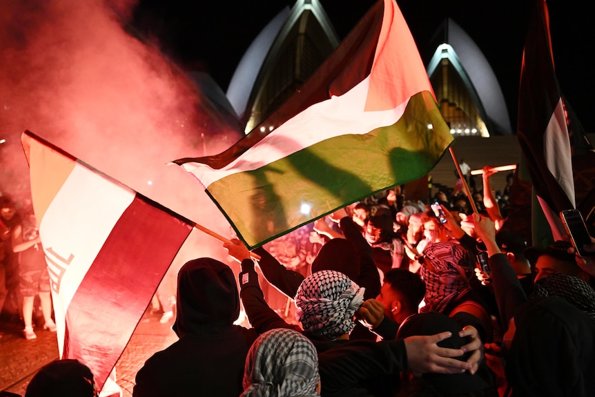 Palestinian flag waved in front of Sydney Opera House with flares