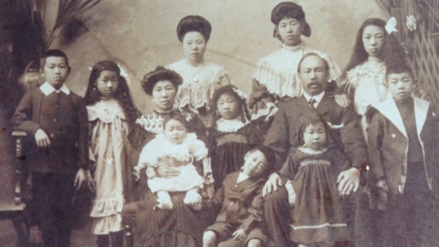 Formal black and white photo of a large family about 1910.