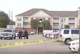 Photo shows police tape in front of an apartment building. 