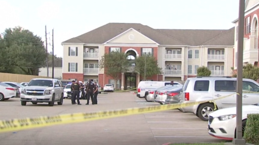 Photo shows police tape in front of an apartment building. 