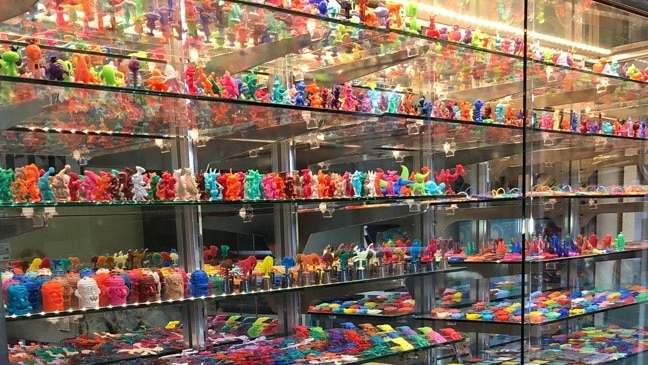 glass cabinet full of miniature coloured plastic toys