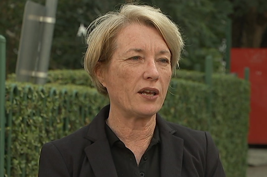 a woman with short blonde hair talking on a street