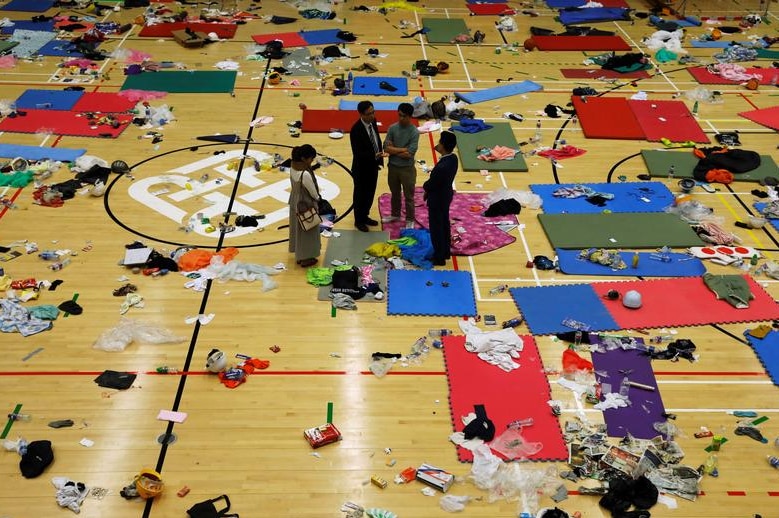 People standing amid matts, and other items left behind by protesters at university.