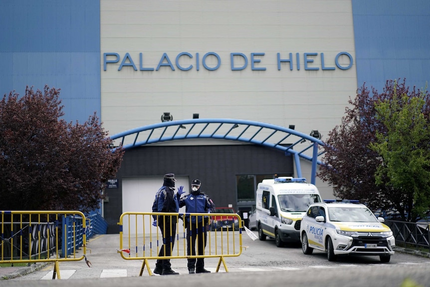 Ves la barricada hacia el edificio azul y gris que dice 'Palacio de Helio'.