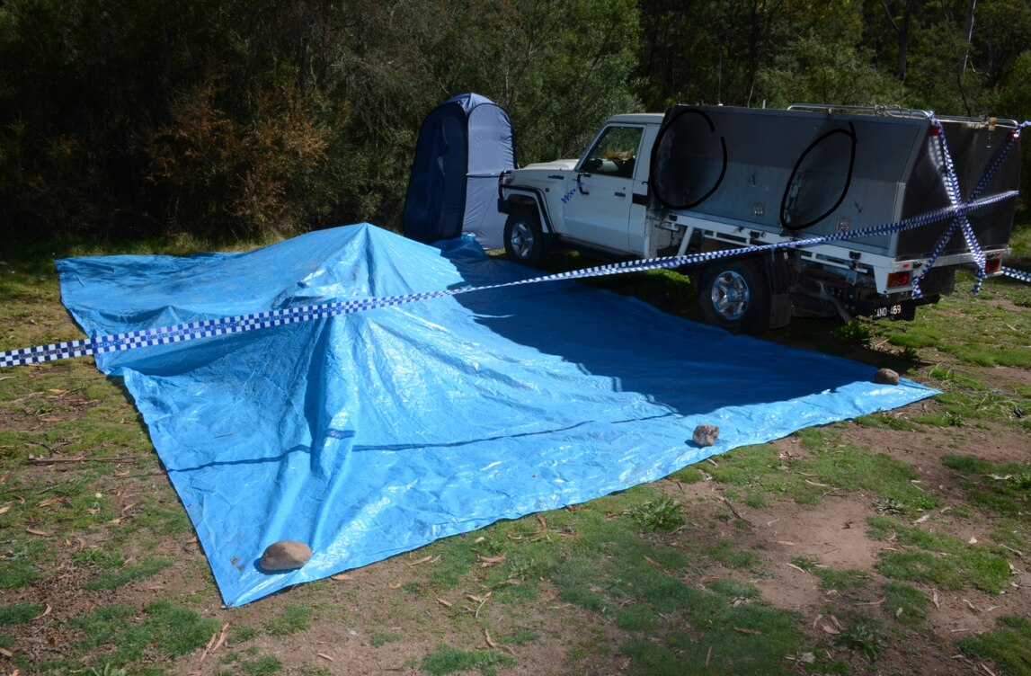 A blue tarpaulin covers part of the campsite at Bucks Camp, which is bordered by police tape.