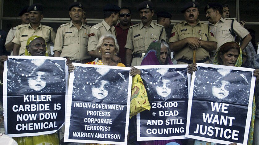 Victims of the Bhopal gas tragedy hold posters during a demonstration outside a court