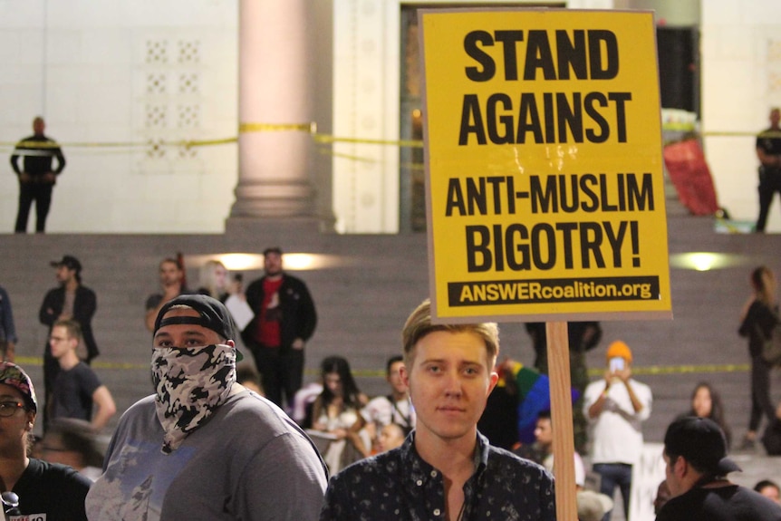 Demonstrator protests peacefully against Trump presidency in downtown LA.