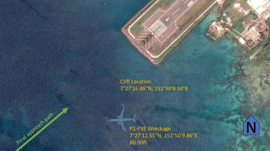 An aerial view shows an airliner lying submerged off the end of a runway.