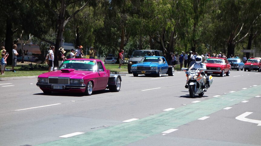 Cars with a police escort taking part in the Summernats Citycruise in Canberra.