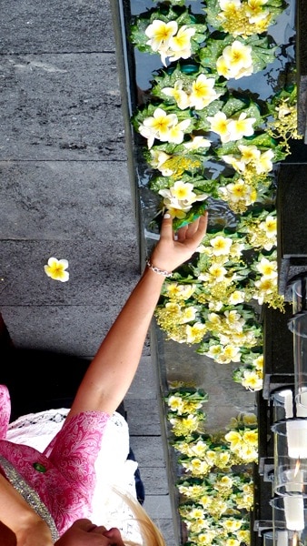 People place flowers in the water at the memorial service in Jimbaran, Bali.