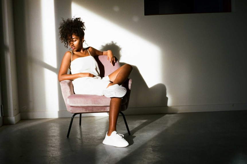 Vanessa Marian sits in a chair wearing a white outfit