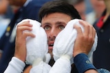 Novak Djokovic, of Serbia, puts an ice towel to his face during a changeover at the US Open.