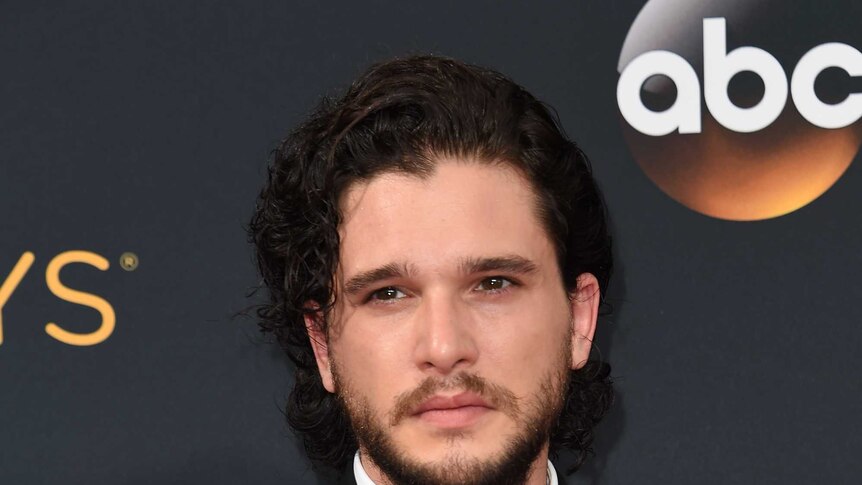 Kit Harrington at the 2016 Emmy Awards in a black suit looking broody