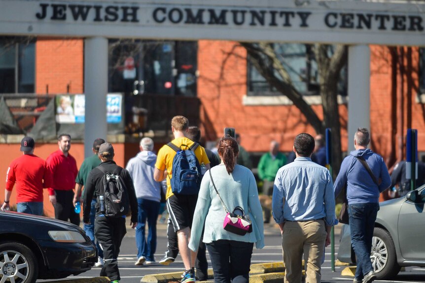 Students walking towards a sign that says "Jewish Community Center" in Louisville, Kentucky