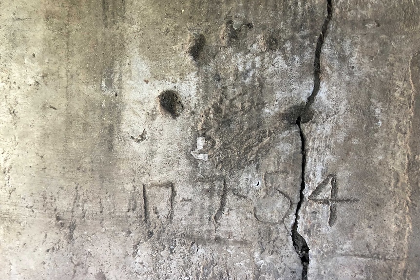 A worn child's handprint in a concrete slab, with the date 17.7.54.