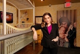 Lisa Marie Presley stands next to her childhood crib 